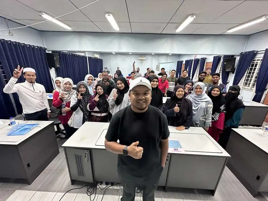 A group of people in a training session, with one person giving a thumbs-up at the front. Others in the background are smiling and making peace signs, creating an atmosphere of positivity and camaraderie. CK Media