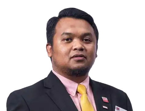Man in a suit with a pink shirt and yellow tie, wearing a name tag, looking at the camera against a white background. CK Media